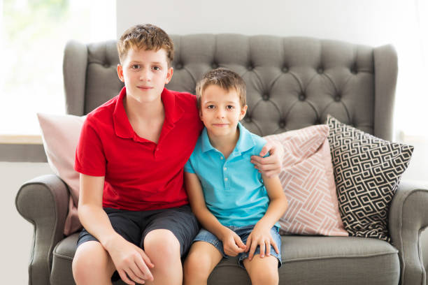 Older Brother On The Sofa Hugging Younger Brother Stock Photo - Download  Image Now - Brother, Old, Child - Istock