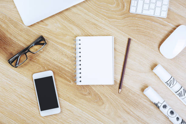 istock Wooden desktop with smartphone and notepad 937923432