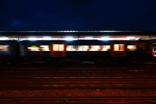 Commuter train departing a UK station at night