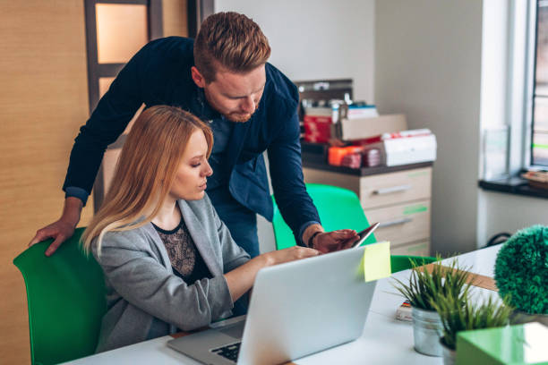 istock Two business people working together in the office 937933252