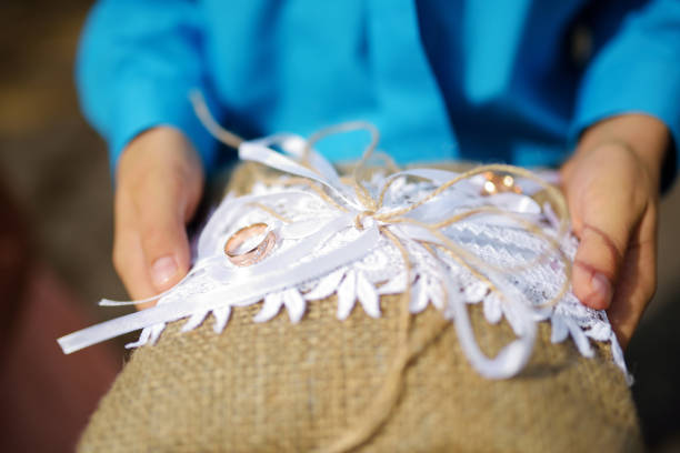 istock Child holding a pillow with the wedding rings on it 937933920