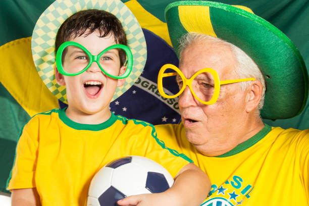 istock grandson and grandfather supporting Brazilian team 937933956