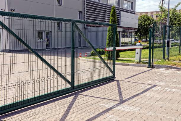 緑の金属のゲートおよび工業ビル前の歩道に障壁 - door facade house front view ストックフォトと画像