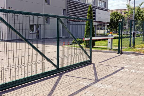 portão de metal verde e barreira na calçada em frente ao prédio industrial - iron fence - fotografias e filmes do acervo
