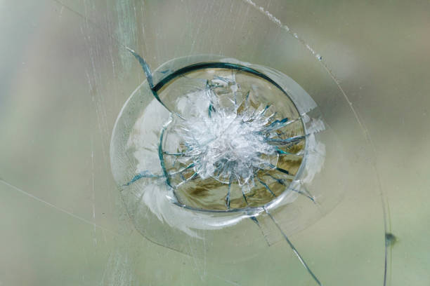 istock Firearms bullethole on bulletproof glass, cracks background 937936594
