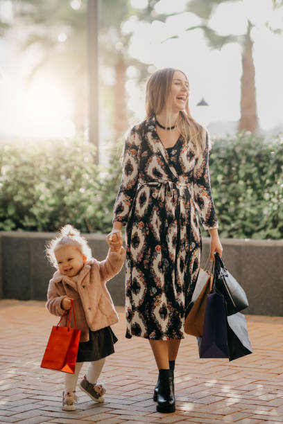 mother and daughter are walking on the street - boutique shopping retail mother imagens e fotografias de stock