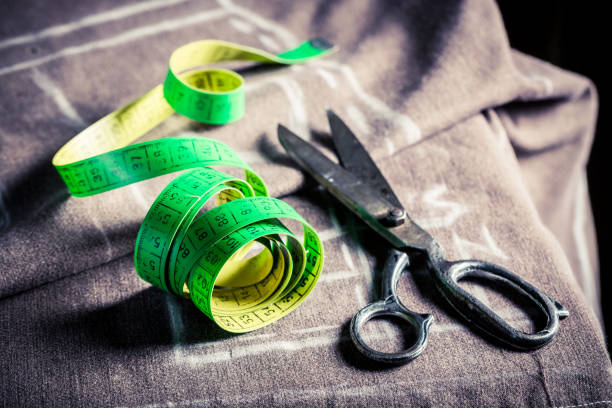 istock Closeup of tailor's table with cloth and scissors 937953272
