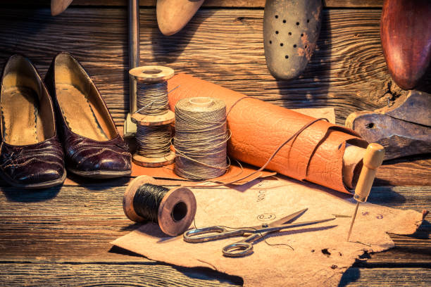 istock Shoes, leather and tools in vintage cobbler workshop 937962784