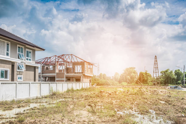 istock Residential new house building at construction site with clouds and blue sky 937972792