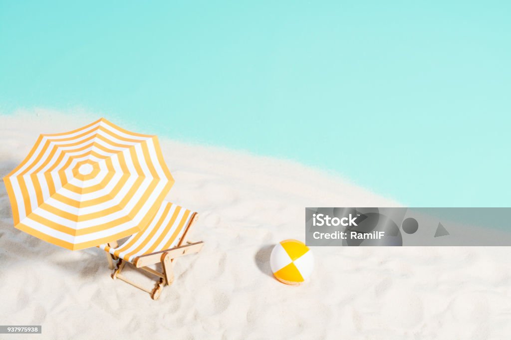 Lounge chair with parasol and beach ball on the coast Lounge chair with parasol and beach ball on the coast, top view Beach Stock Photo