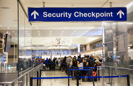 Los Angeles, California, USA-December 2017: Airport Sign at the entrance of the security checkpoint in LAX airport with People waiting in line.