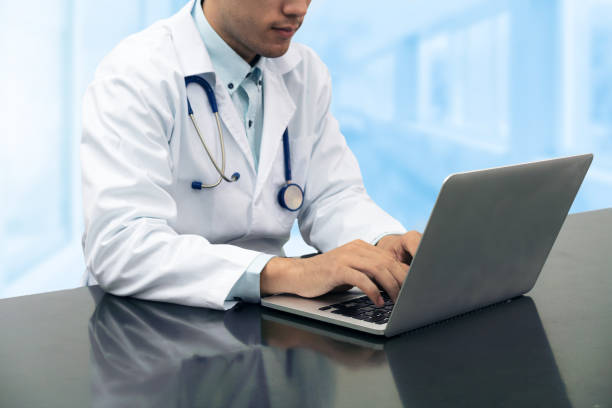 istock Doctor working on desk with laptop 937982962