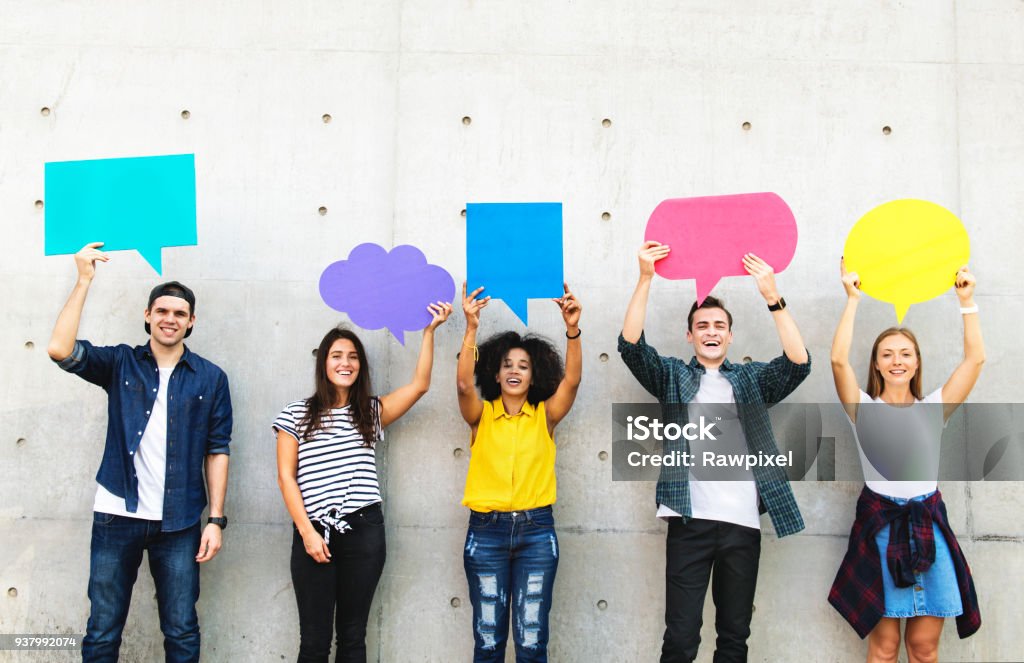 Group of young adults outdoors holding empty placard copyspace thought bubbles Teenager Stock Photo