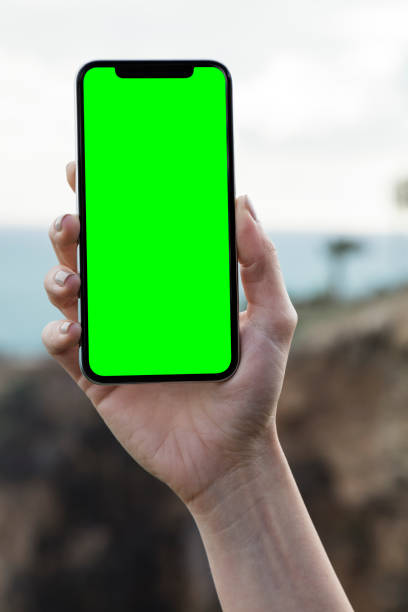 kobieta ręka gospodarstwa telefon komórkowy z chroma green - people letter x isolated holding zdjęcia i obrazy z banku zdjęć