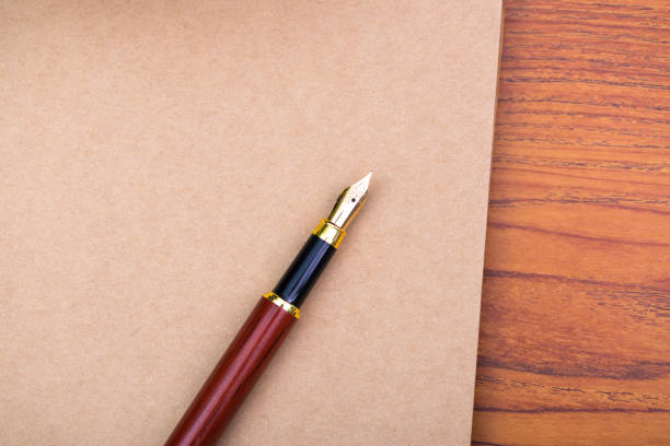 istock Fountain pen or ink pen with notebook paper on wooden working table with copy space, office desk concept. 938004402