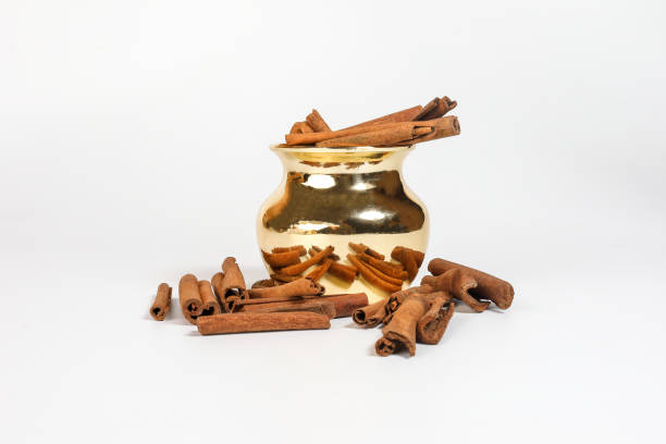 istock Cinnamon spice golden brass copper metal shiny pot container on white background 938007942
