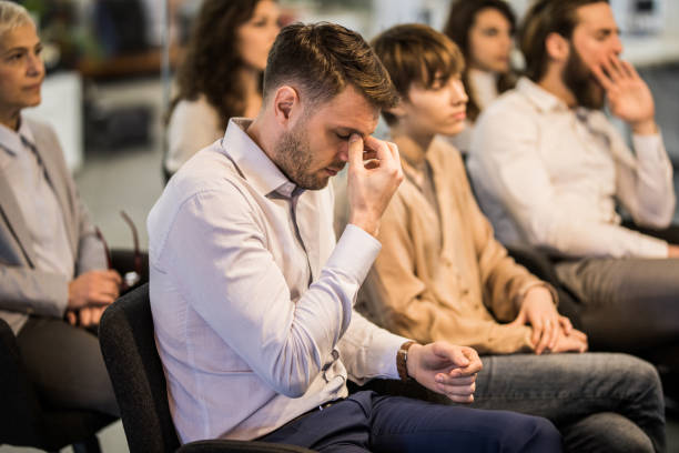 istock Young businessman having a headache on education event in a board room. 938024358