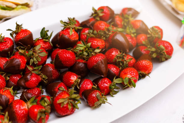 istock Fresh strawberries dipped in dark chocolate on blue wooden background 938027206