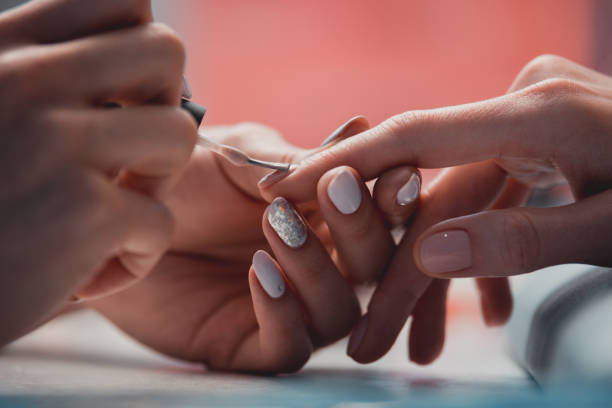 braço de mestre mulher aplicar laca no salão de beleza - manicure - fotografias e filmes do acervo