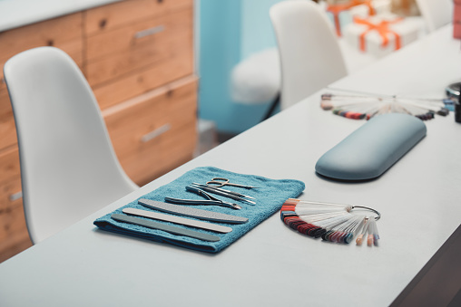 Tools and manicure utensils situating on desk in modern salon