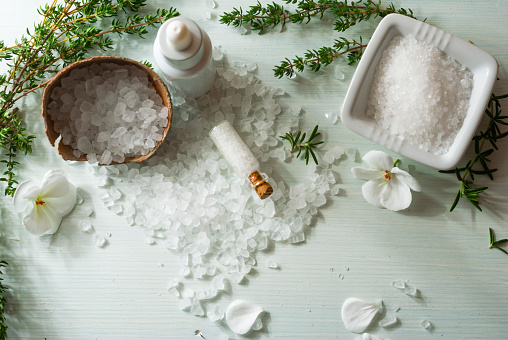 salt with flowers and savory twigs on white wood table