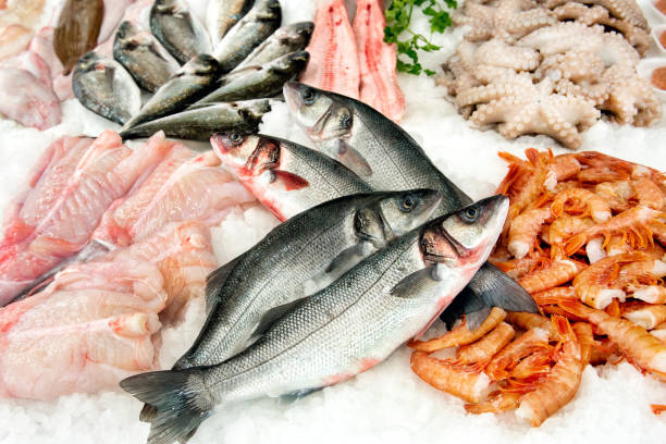 Different kinds of fish on market display Various types of fresh fish lying in ice on market display fish market photos stock pictures, royalty-free photos & images