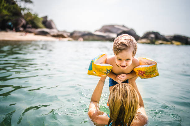 istock Cute kid having fun with his mother in the sea. 938034190