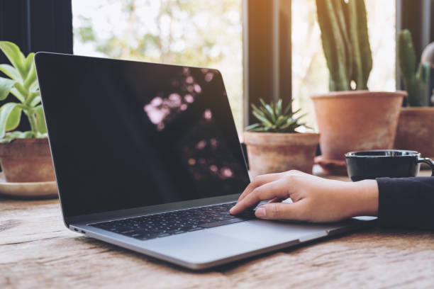 istock Woman's hands using and typing on laptop on vintage wooden table in cafe 938038770