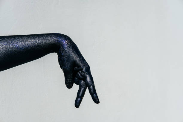 istock Shadow play Black Hand of death with Sparkles on a gray background 938042112
