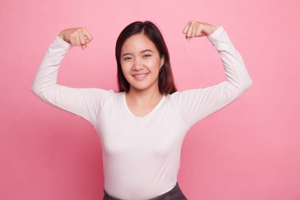 istock Beautiful young Asian woman flex bicep. 938046758