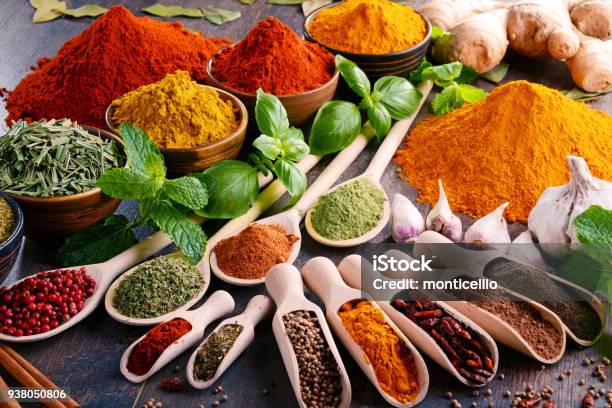 Variety Of Spices And Herbs On Kitchen Table Stock Photo - Download Image Now - Spice, Seasoning, Condiment