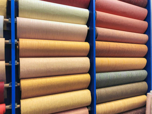 istock Colored wallpaper rolls on store shelves. Paper material for repair 938056866