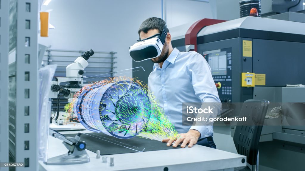 Factory Chief Engineer Wearing VR Headset Designs Engine Turbine on the Holographic Projection Table.  Futuristic Design of Virtual Mixed Reality Application. Virtual Reality Simulator Stock Photo