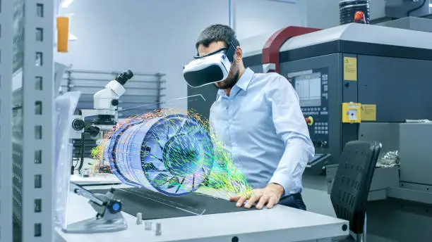 Factory Chief Engineer Wearing VR Headset Designs Engine Turbine on the Holographic Projection Table.  Futuristic Design of Virtual Mixed Reality Application.