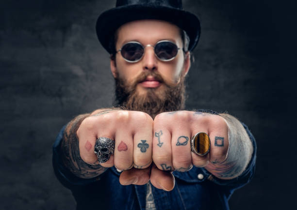 istock Close-up tattooed hipster's fingers with rings. 938057592