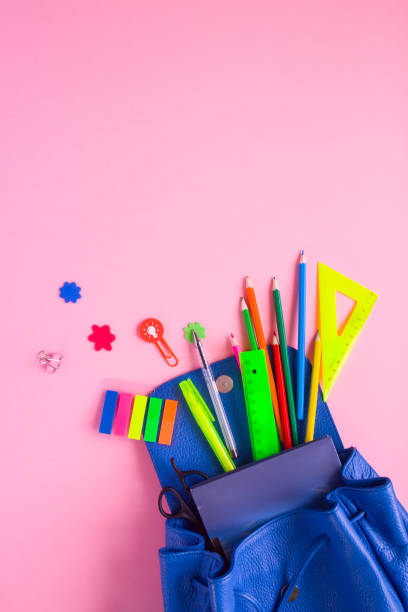 istock Blue backpack with school supplies on pink background 938061168