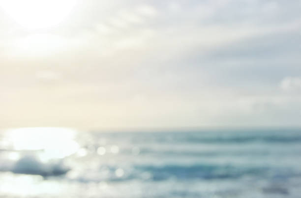 istock background of blurred beach and sea waves with bokeh sunset light. 938070940