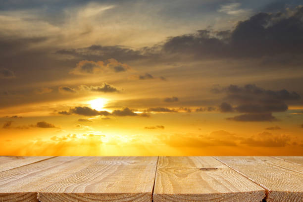 istock wood board table in front of golden sunset. product display background. 938072024