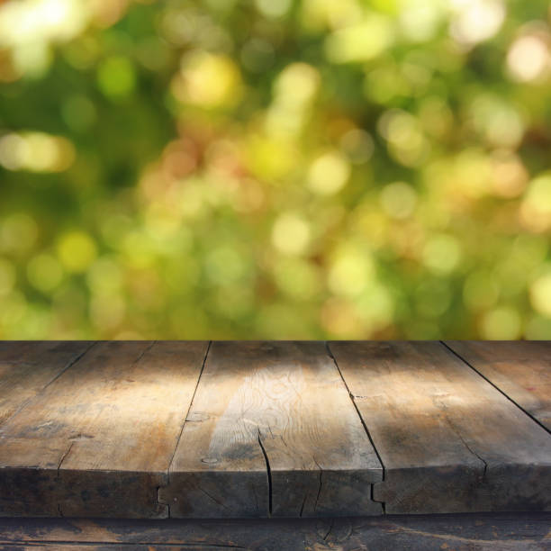 istock Empty rustic table in front of green spring abstract bokeh background. product display and picnic concept. 938072580