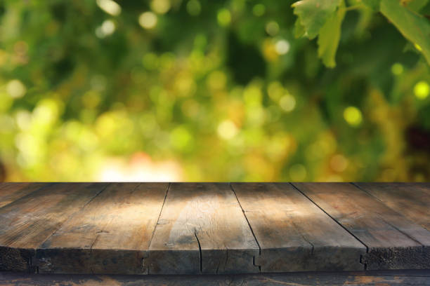 istock Empty rustic table in front of green spring abstract bokeh background. product display and picnic concept. 938072598