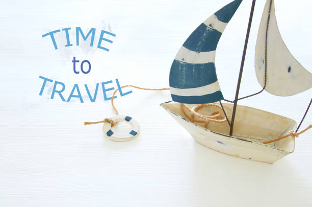 istock nautical concept with white decorative sail boat over white wooden table. 938075290