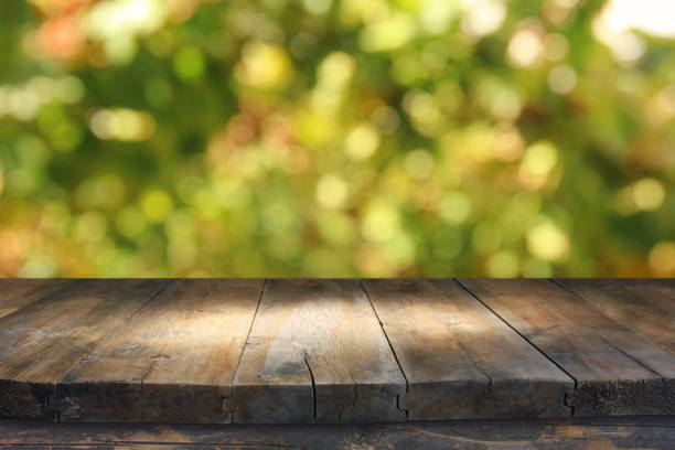 istock Empty rustic table in front of green spring abstract bokeh background. product display and picnic concept. 938075296
