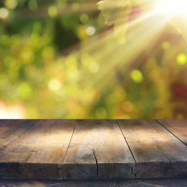 istock Empty rustic table in front of green spring abstract bokeh background. product display and picnic concept. 938075302