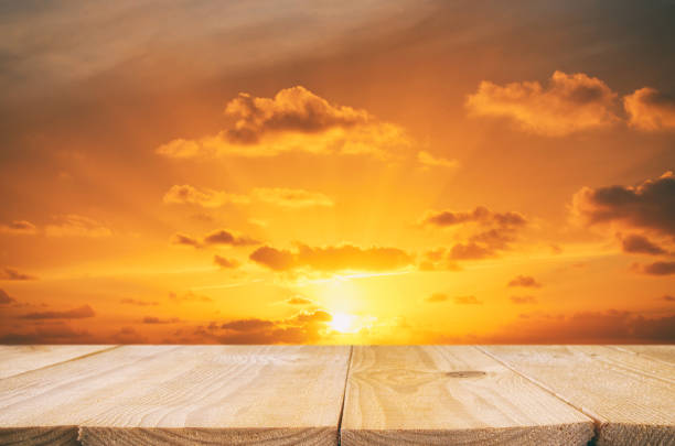 wood board table in front of golden sunset. product display background.