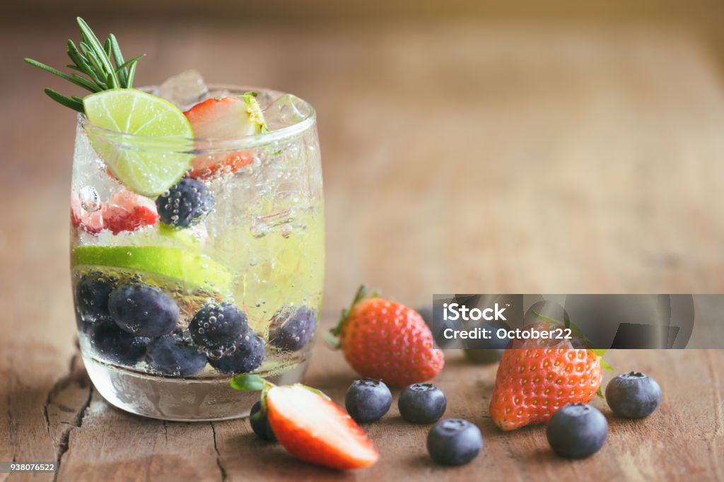 Imprégné d’eau issu de myrtille fraise et citron dans l’eau minérale pétillante look fraîcheur tant et sain. Mélanges de fruits mojito sur table en bois avec espace de copie. Concept de boisson rafraîchissante l’été. - Photo de Eau libre de droits