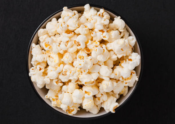 istock Black bowl with fresh salted popcorn on wood 938079296