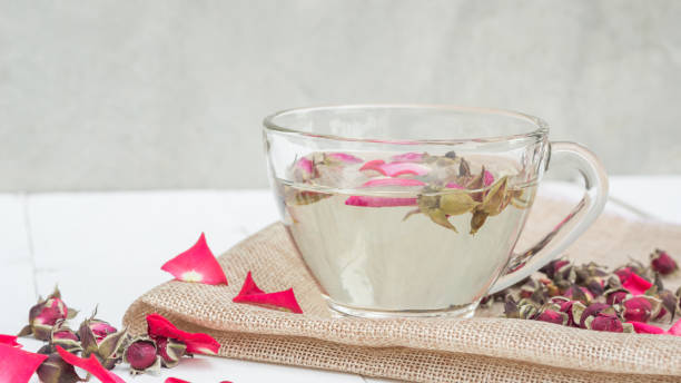 istock A cup of tea pink rose on a white wooden table. 938079852