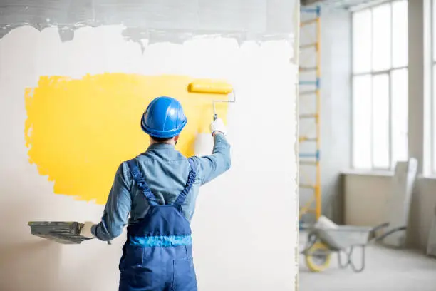 Photo of Workamn painting wall indoors