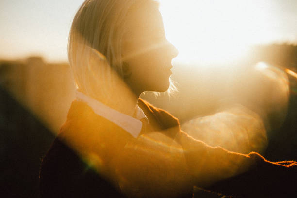 Portrait of young beautiful Caucasian woman in nature scene with backlit.