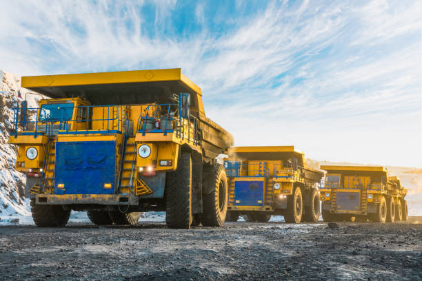 istock Large quarry dump truck. Loading the rock in dumper. Loading coal into body truck. Production useful minerals. Mining truck mining machinery, to transport coal from open-pit as the Coal Production. 938088158